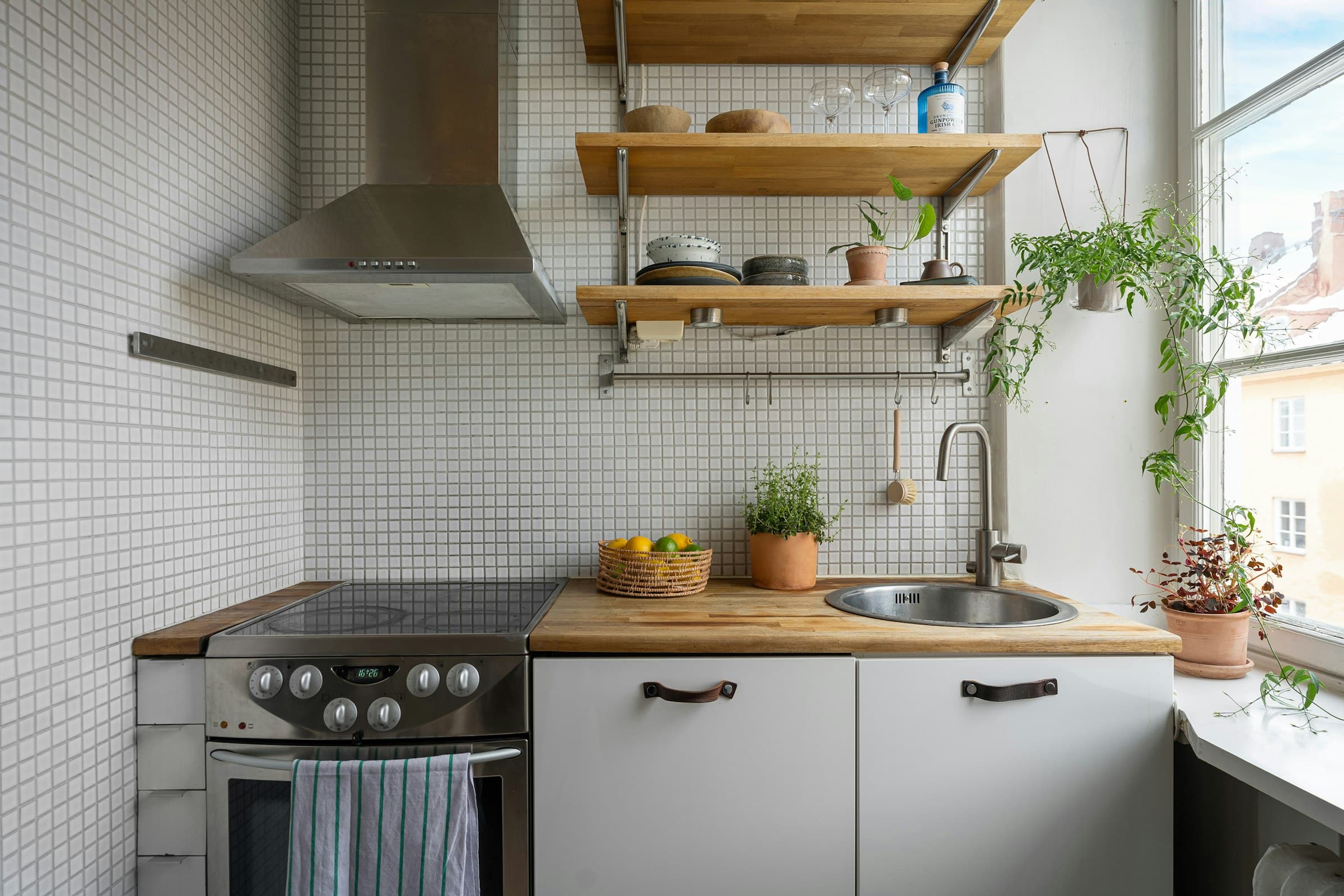 Kitchen with white tiles, open shelves, an oven and a window (placeholder photo)